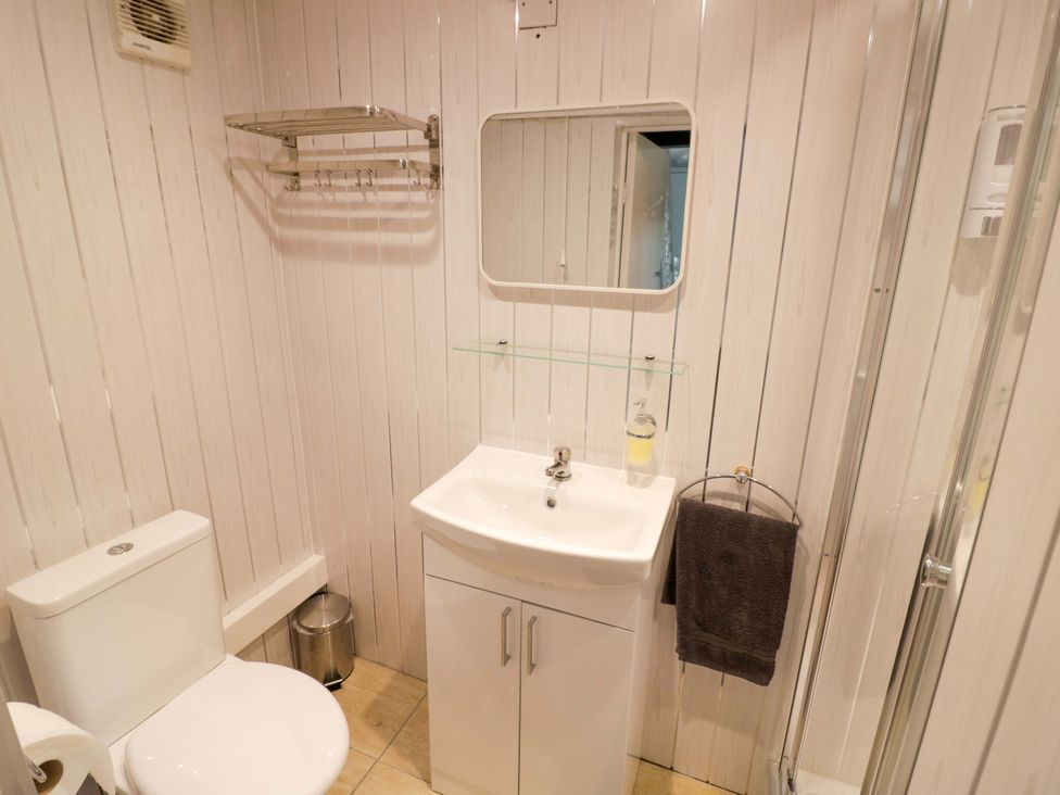 A bathroom with a sink, toilet and shower at The Golden Cross Cottage Evesham