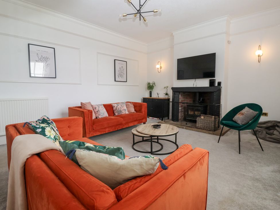 A living room with sofas, a table, and a television at The Grange in Flamborough