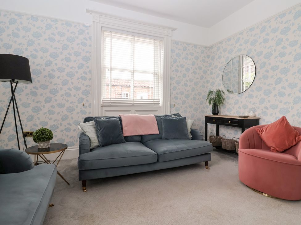 A living room with a sofa and armchair at The Grange in Flamborough