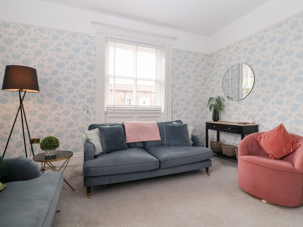 A living room with a sofa and armchair at The Grange in Flamborough