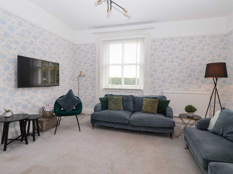 A living room with a sofa and television at The Grange in Flamborough