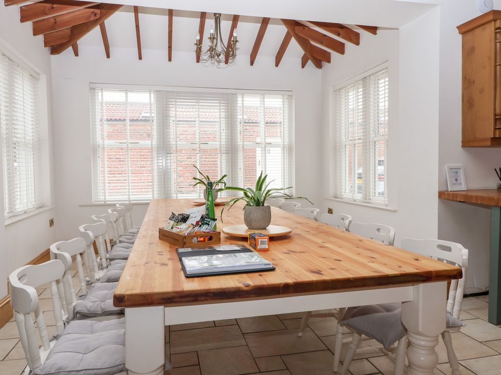 A dining room with a large table and chairs at The Grange in Flamborough