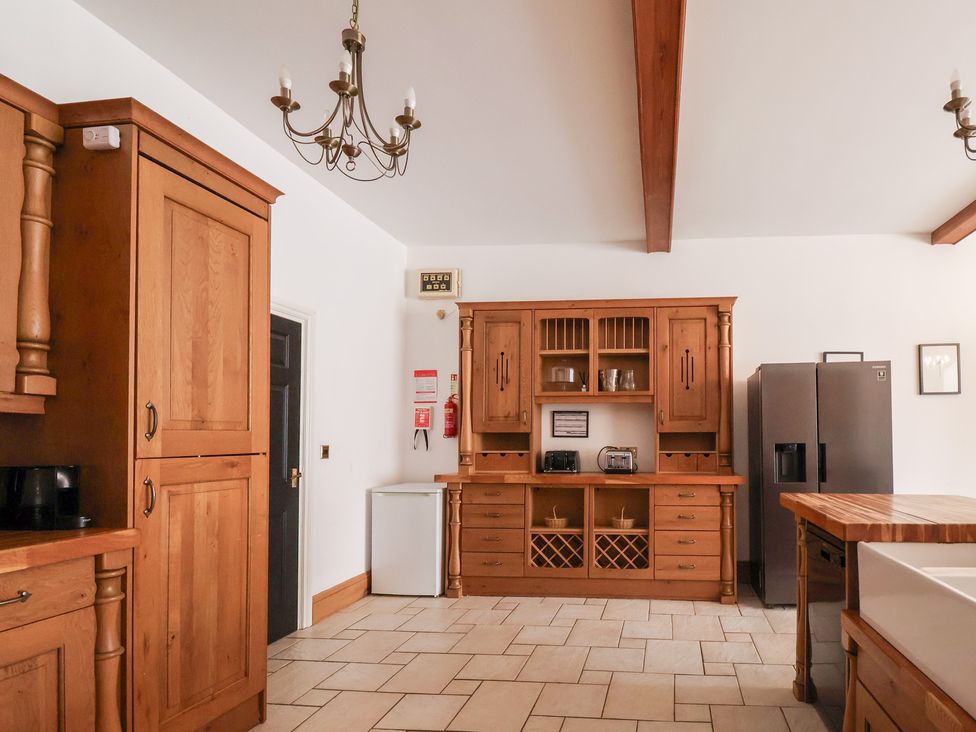 A kitchen with wooden cabinets and appliances at The Grange in Flamborough