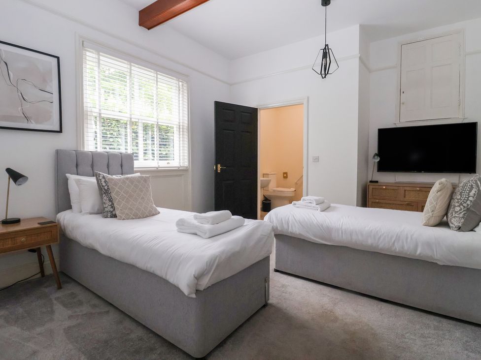 A bedroom with two beds and a tv at The Grange in Flamborough