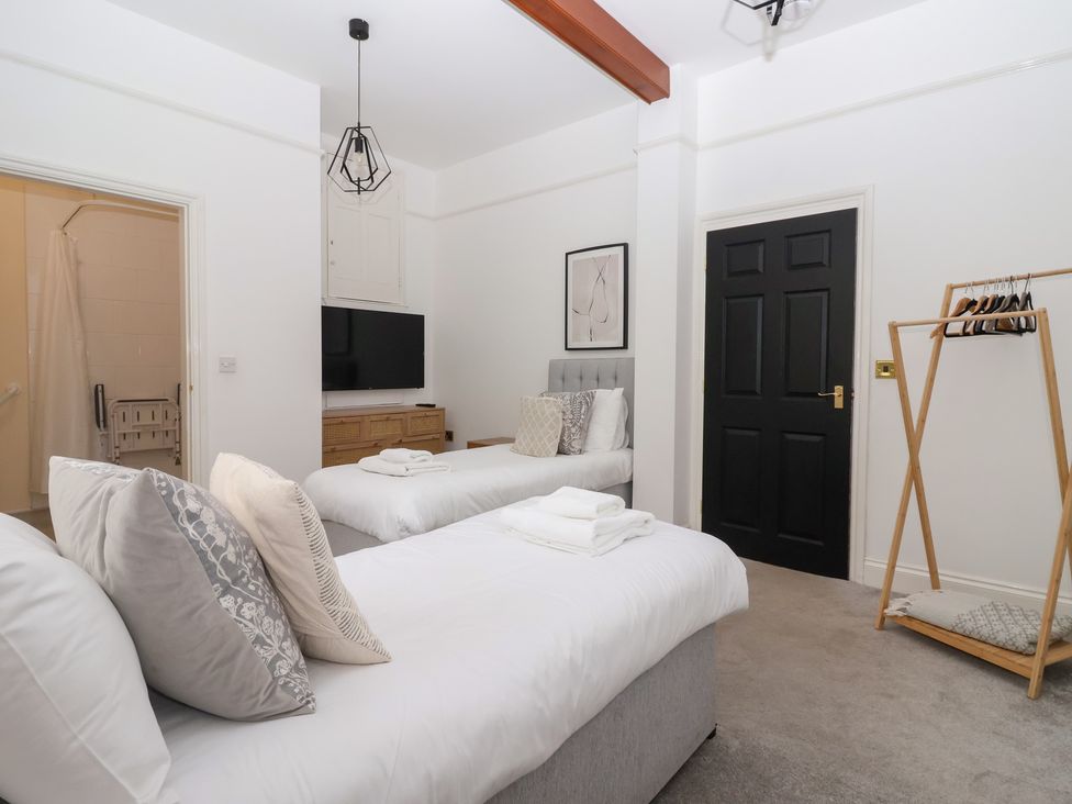 A bedroom with two beds and a television at The Grange in Flamborough