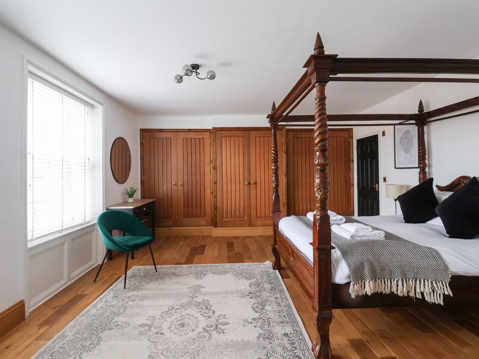 A bedroom with a four-poster bed and wardrobe at The Grange in Flamborough