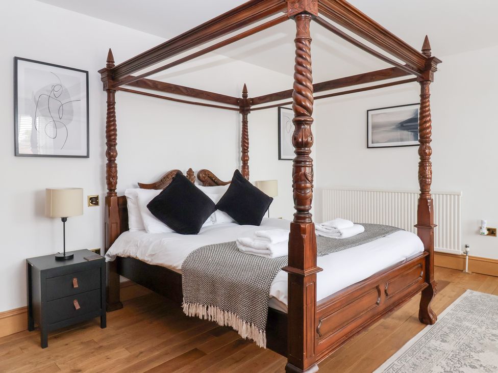 A bedroom with a four-poster bed and bedside table at The Grange in Flamborough