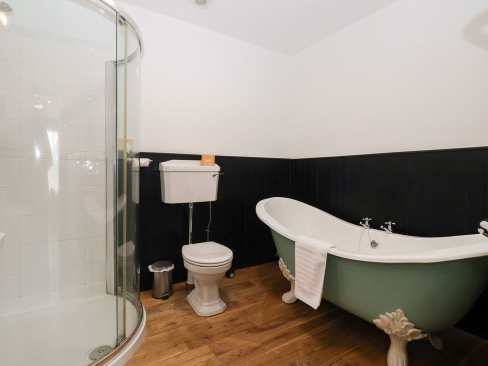 A bathroom with a bathtub, shower, toilet and sink at The Grange in Flamborough