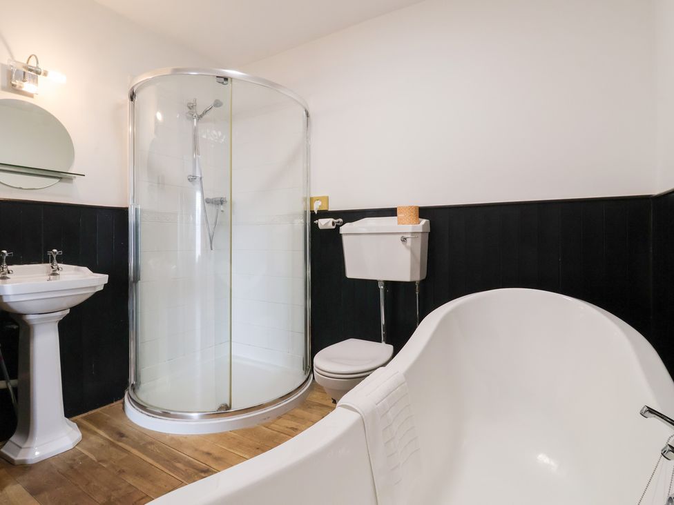 A bathroom with a shower, toilet, sink, and bath tub at The Grange in Flamborough