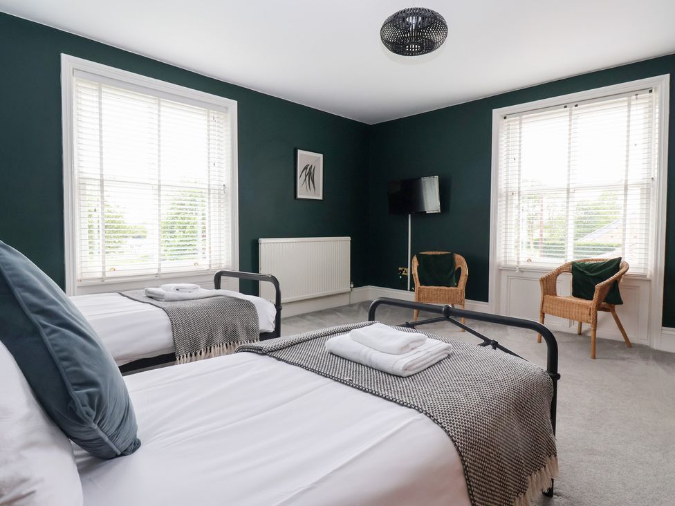 A bedroom with two beds and a television at The Grange in Flamborough