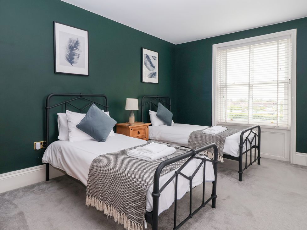 A bedroom with two single beds and a window at The Grange in Flamborough