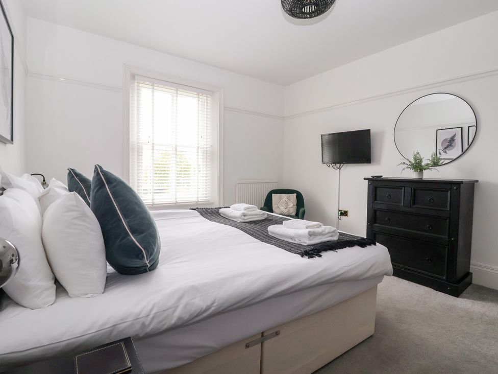 A bedroom with a bed, TV, and dresser at The Grange in Flamborough