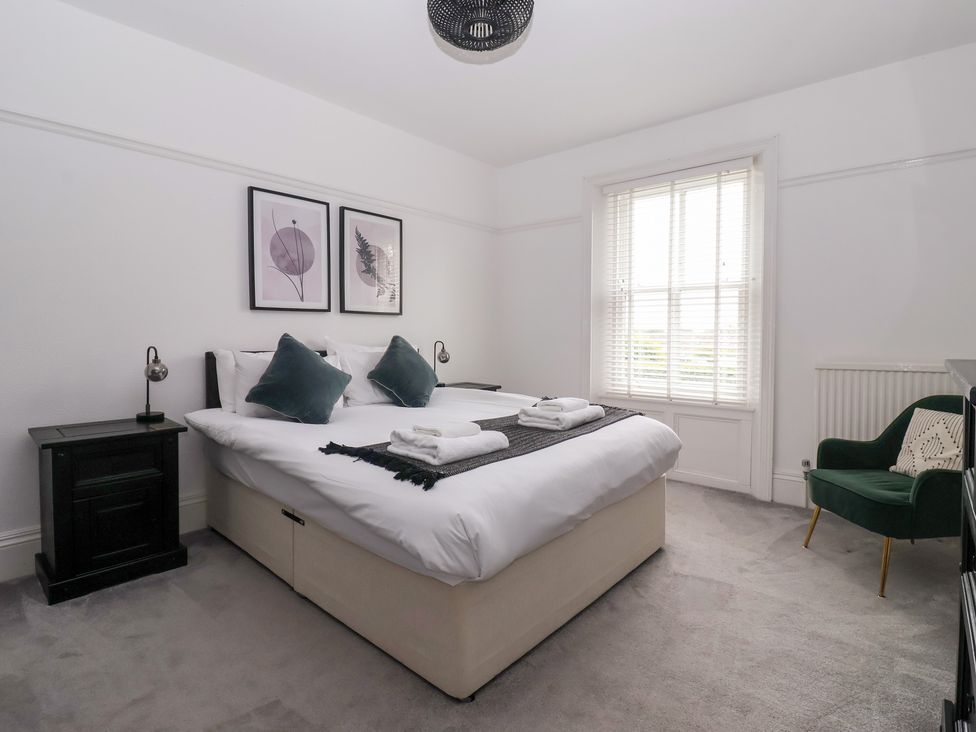 A bedroom with a bed and nightstand at The Grange in Flamborough