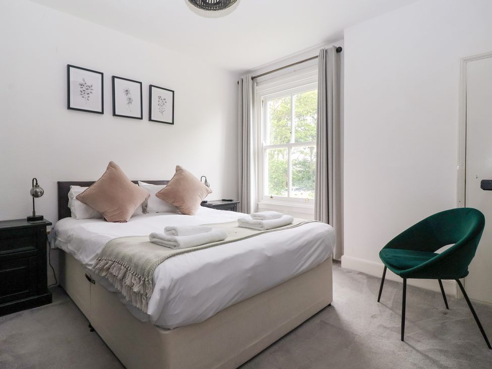 A bedroom with a bed, chair, and window at The Grange in Flamborough