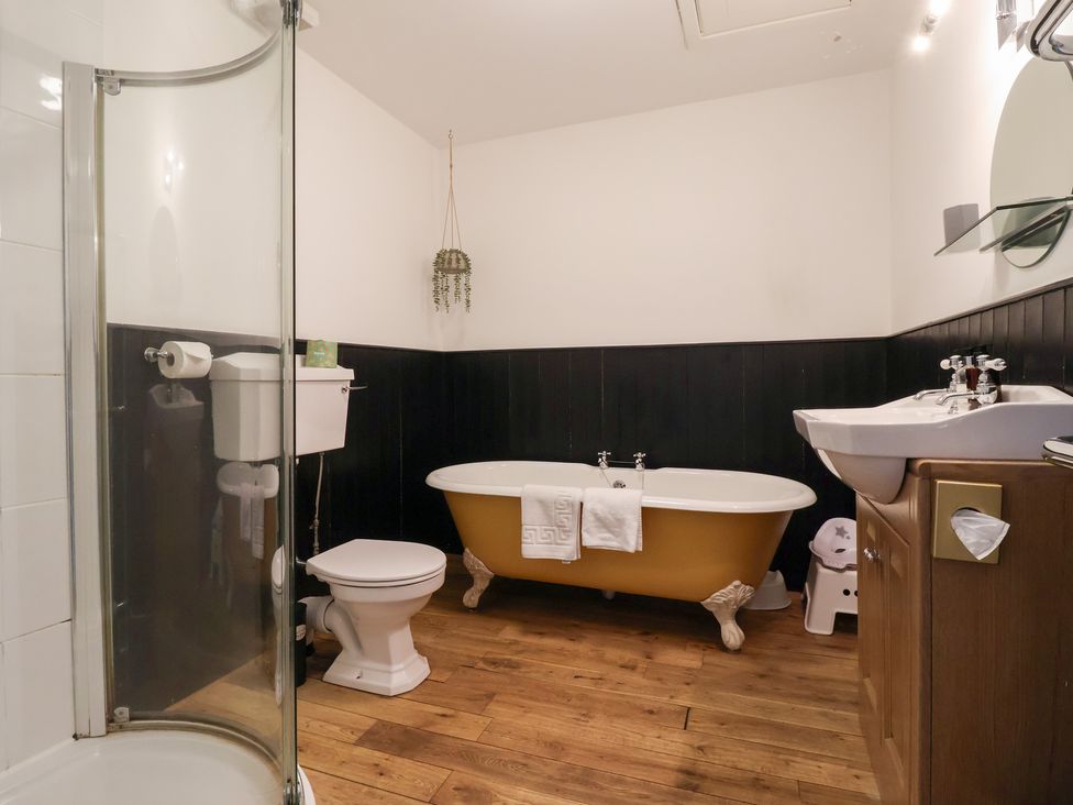 A bathroom with a bathtub, shower, sink, and toilet at The Grange in Flamborough