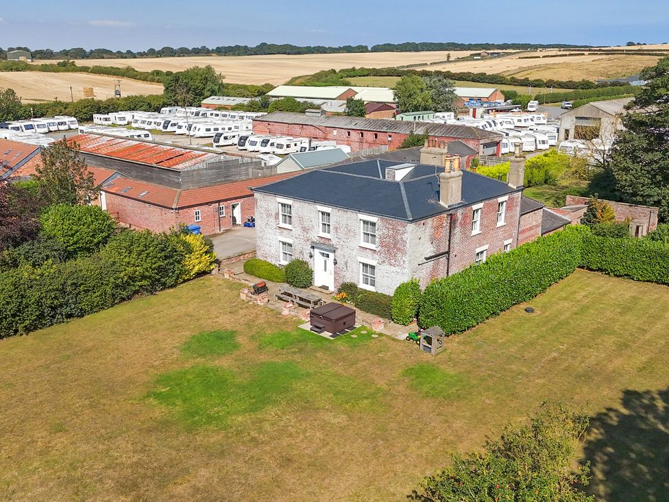 A house with a garden and caravans in the background at The Grange in Flamborough
