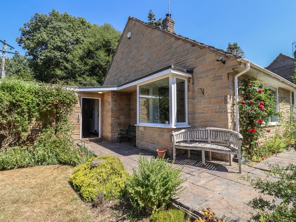 An outdoor area of a house with a bench and garden at Woodstock in Chard