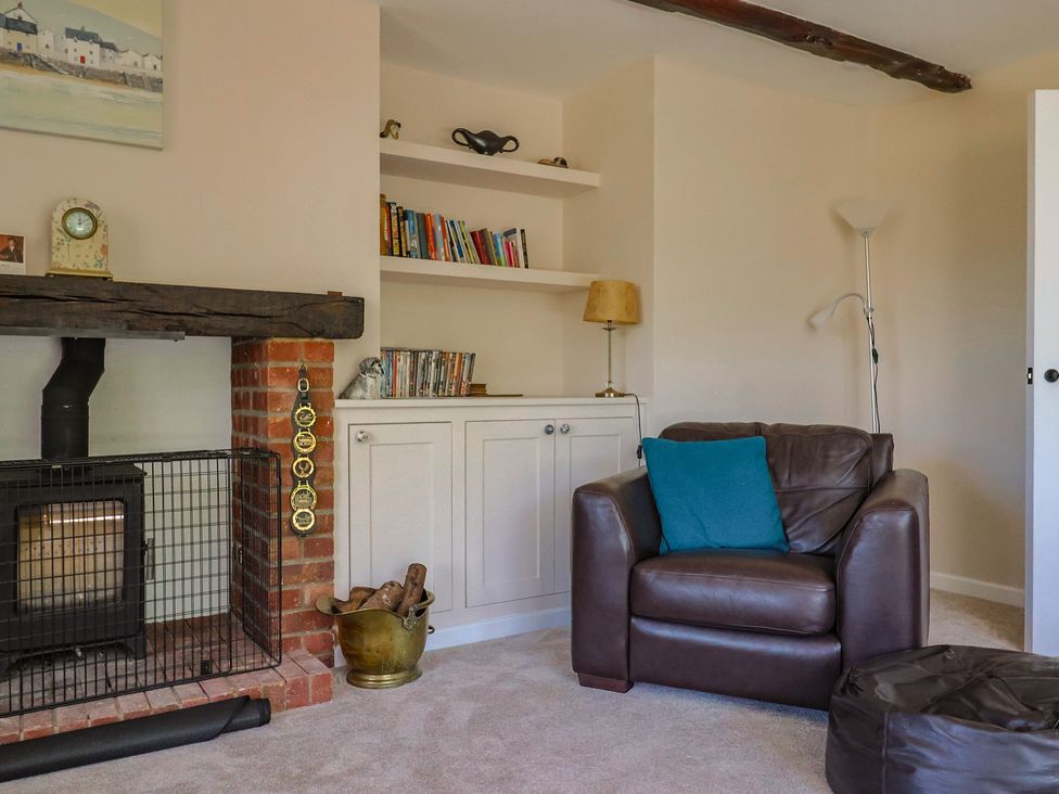 A living room with a fireplace and bookshelf at Woodstock in Chard