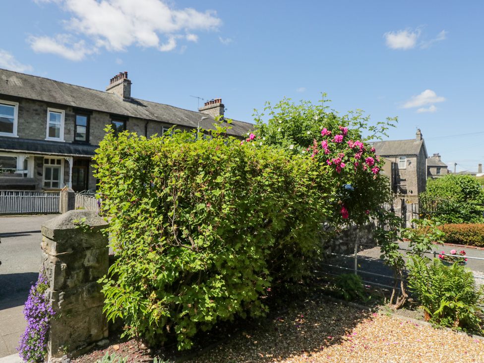 A garden with bushes and flowers at 14 Castle Garth in Kendal