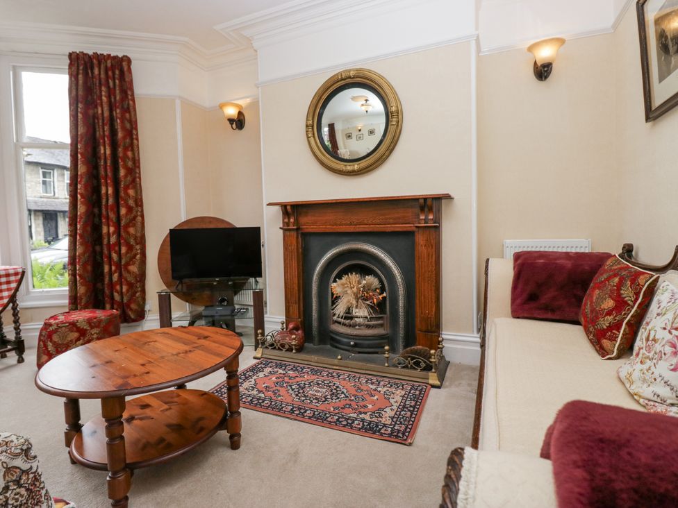 A living room with a fireplace and television at 14 Castle Garth, Kendal