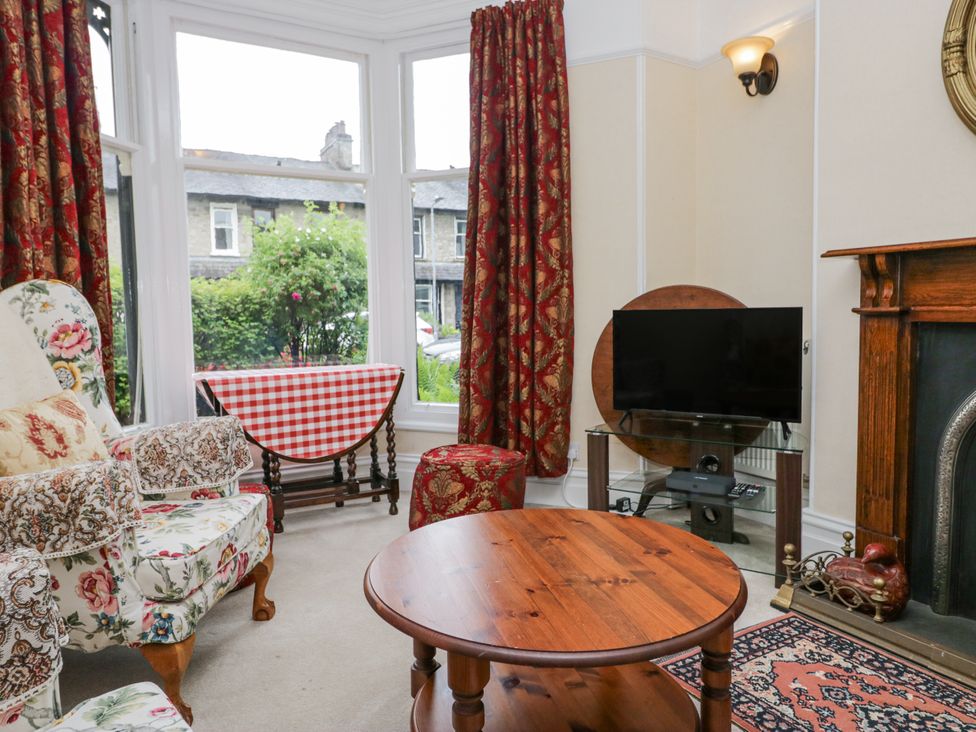 A living room with a coffee table and a television at 14 Castle Garth Kendal