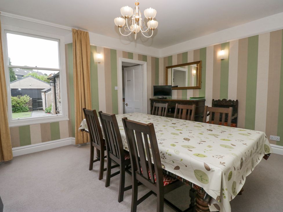 A dining room with a large table and chairs at 14 Castle Garth in Kendal