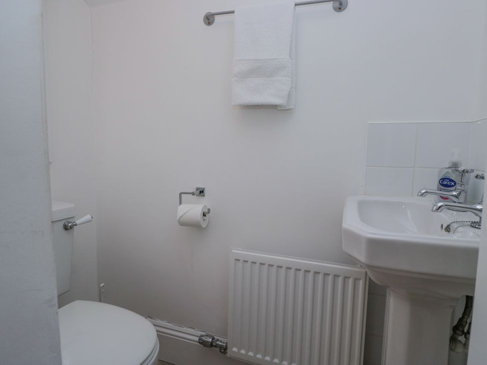A bathroom with a toilet and hand wash basin at 14 Castle Garth Kendal