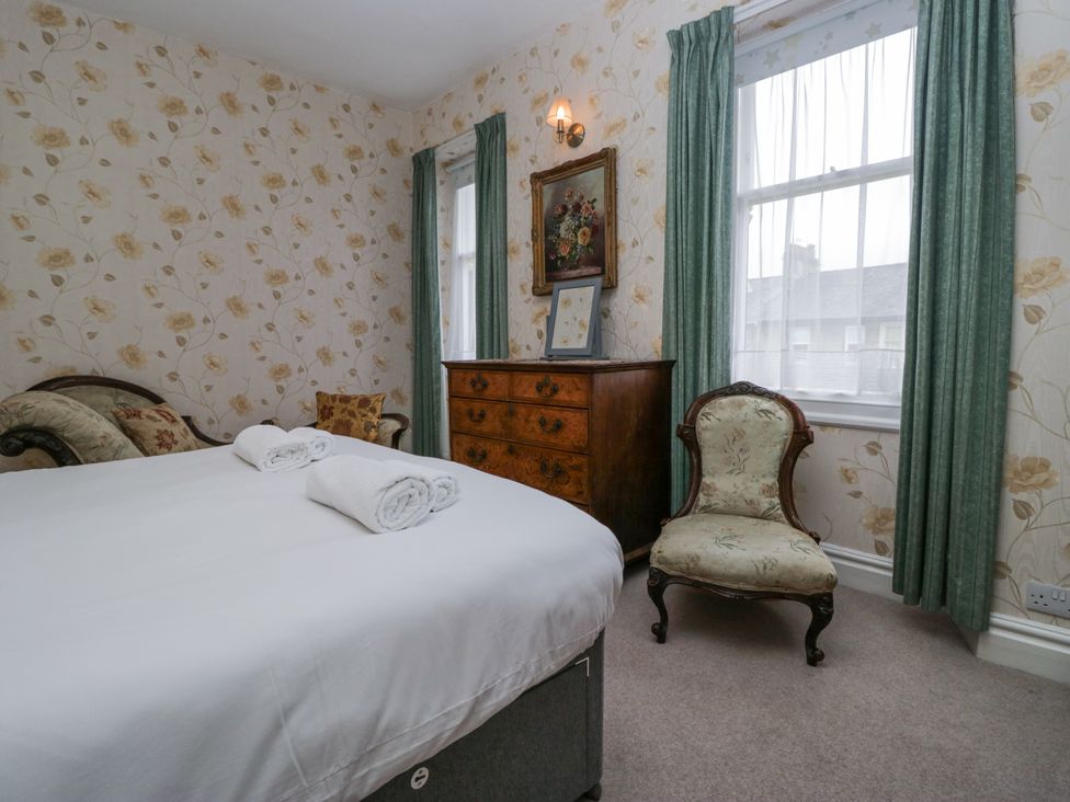 A bedroom with a bed, chest of drawers, and chair at 14 Castle Garth, Kendal