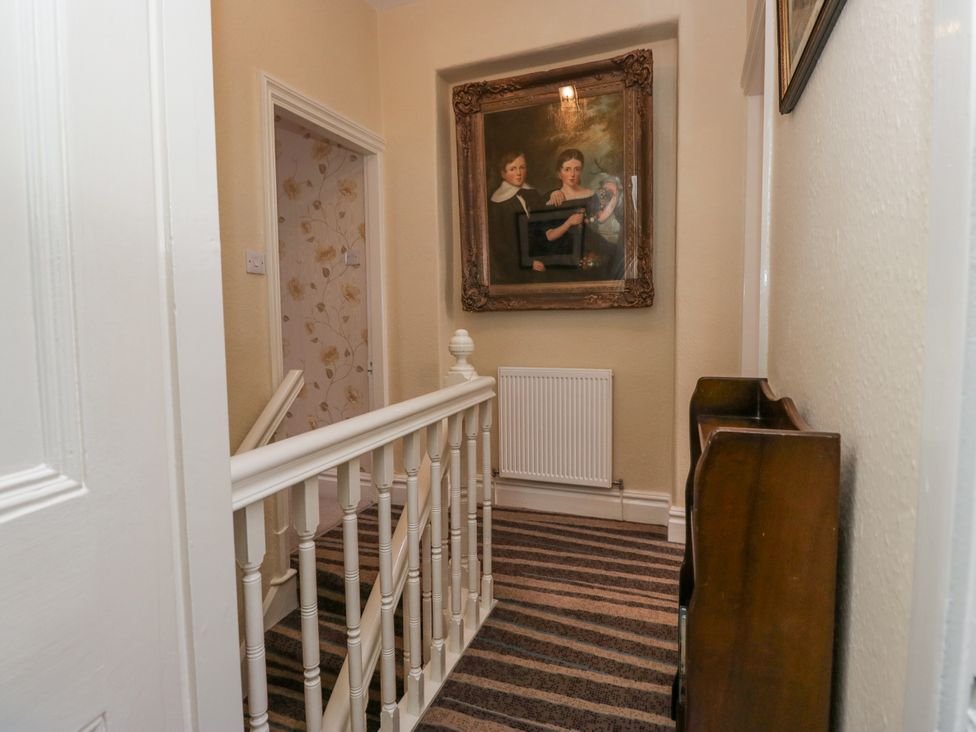 A hallway featuring a staircase and a painting at 14 Castle Garth Kendal