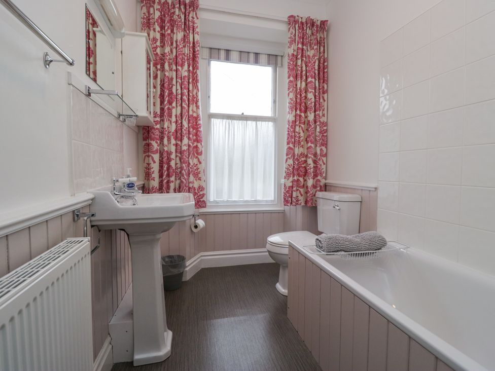 A bathroom with a bath, sink, and toilet at 14 Castle Garth Kendal