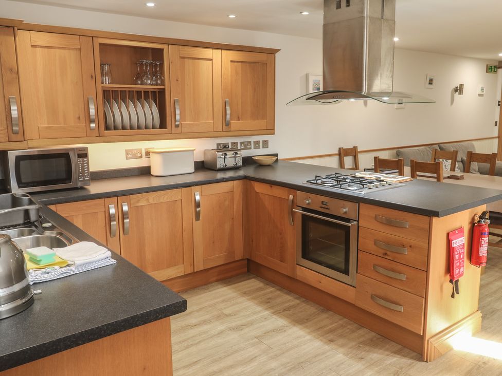 A kitchen with cabinets and appliances at Ash Barn in Falmouth
