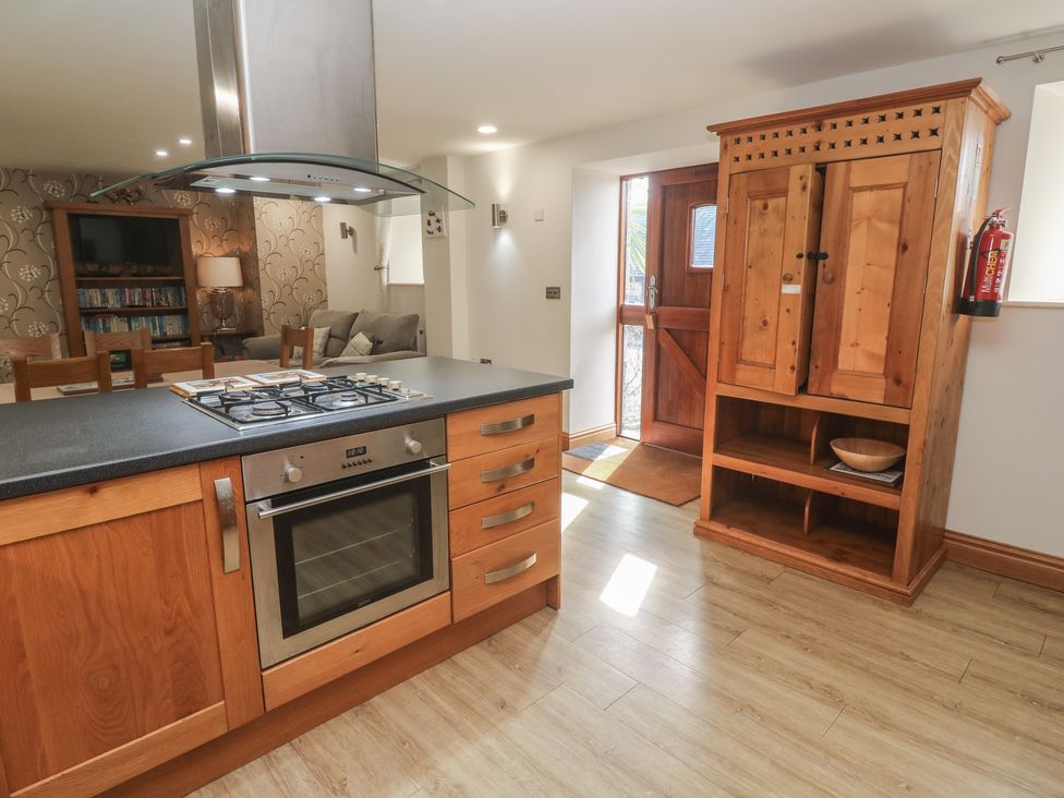 A kitchen with stove and cabinets at Ash Barn in Falmouth