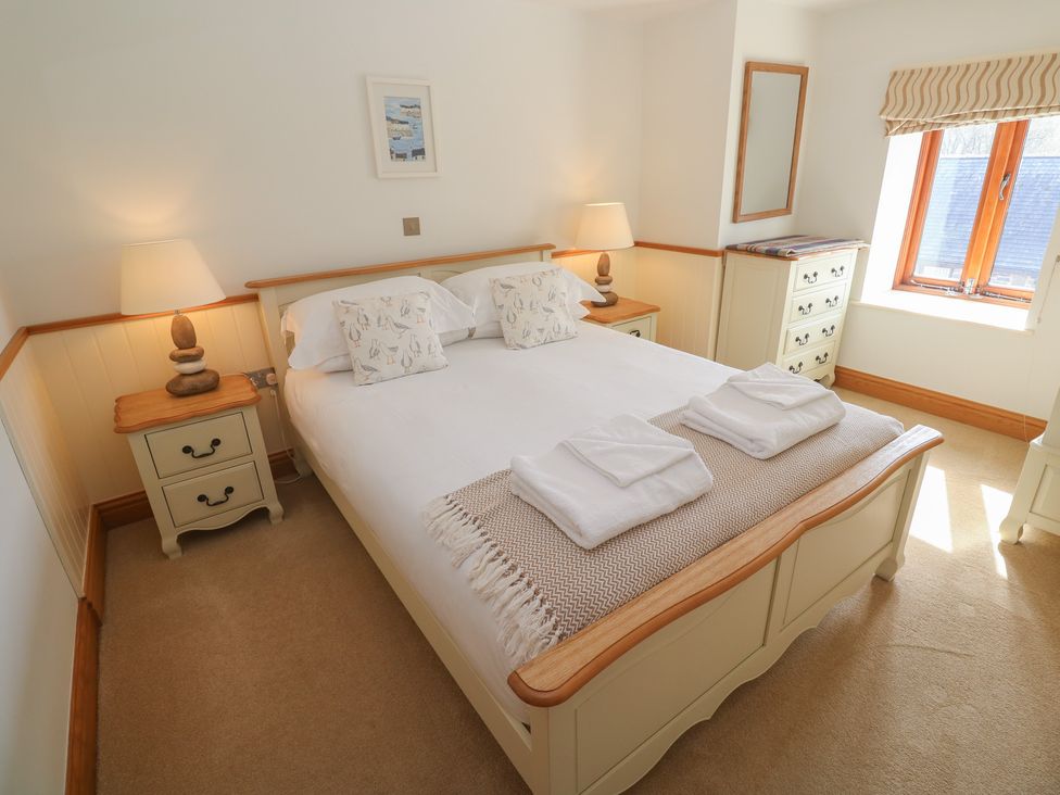 A bedroom with a bed and bedside table at Ash Barn in Falmouth