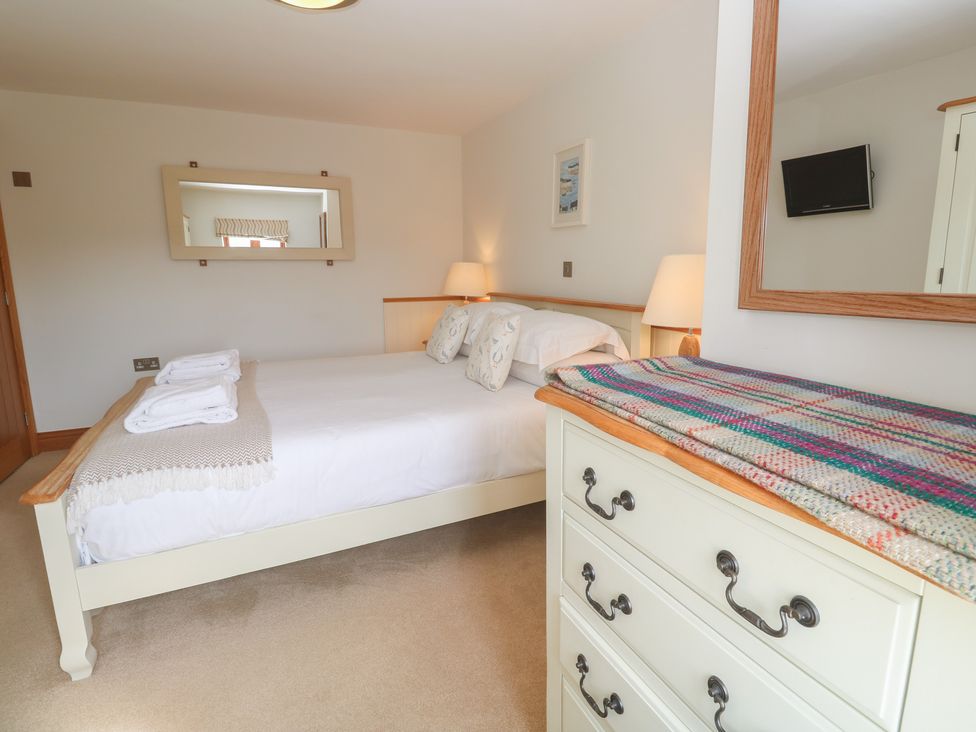 A bedroom with a bed and dresser at Ash Barn in Falmouth