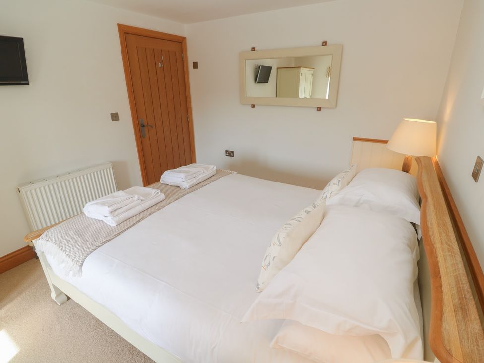 A bedroom with a bed and towels on the bedding at Ash Barn in Falmouth