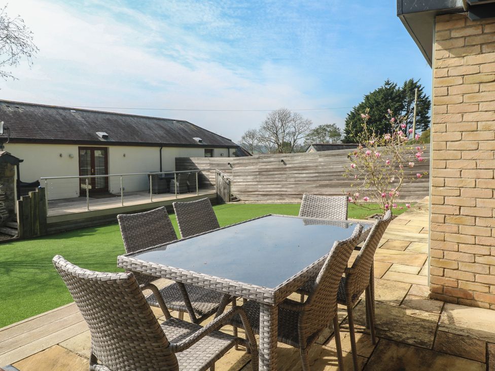 An outdoor dining area with a table and chairs at Ash Barn in Falmouth