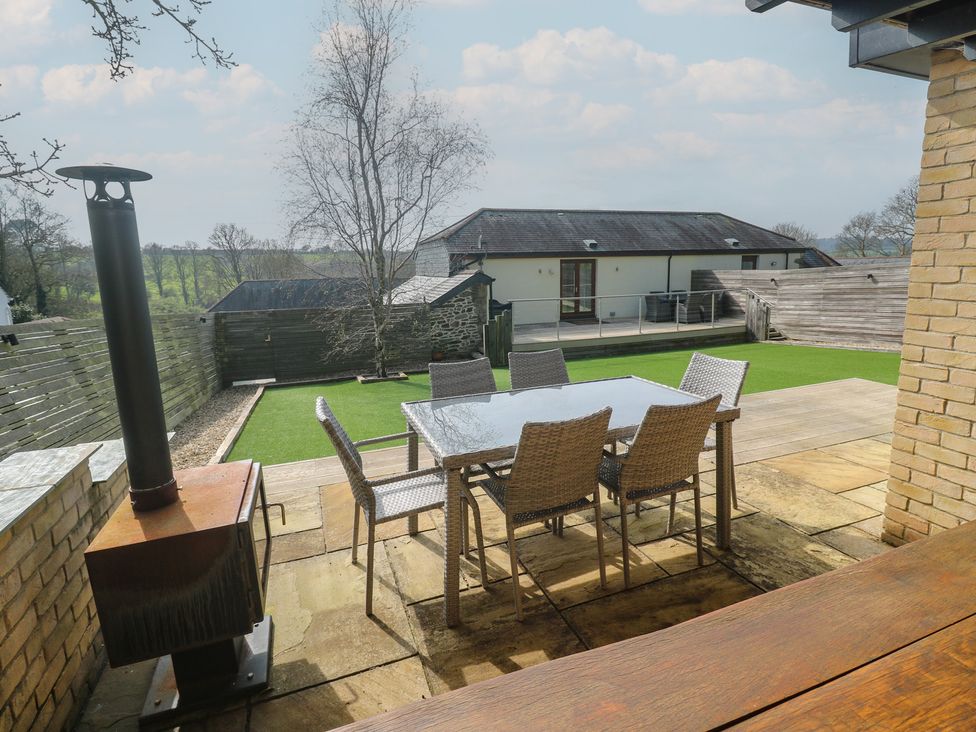 A patio with a table and chairs at Ash Barn in Falmouth