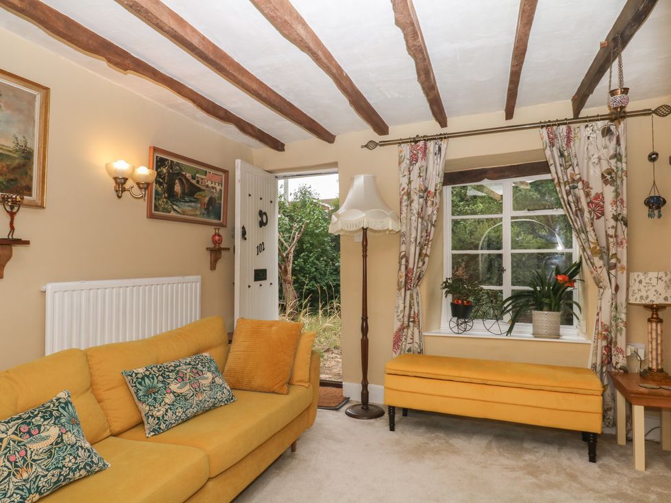 A living room with a sofa and window at Mei Cottage in Pinhoe