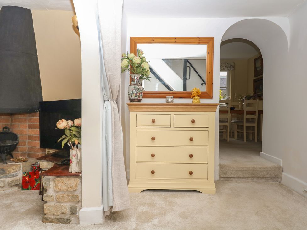 An entryway with a dresser and flowers at Mei Cottage in Pinhoe