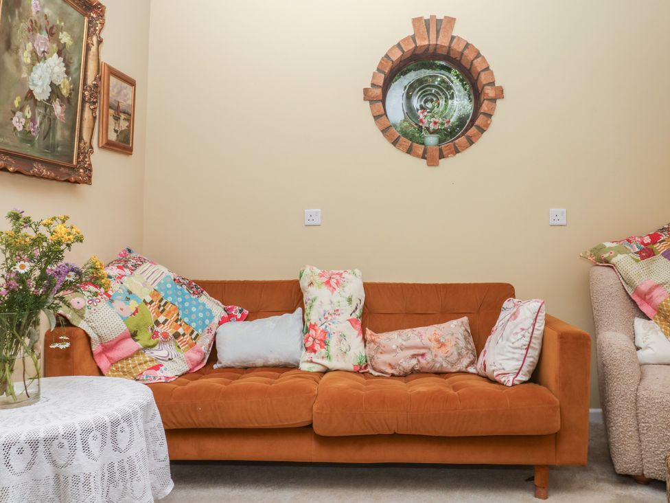 A living room with a sofa and a coffee table at Mei Cottage in Pinhoe