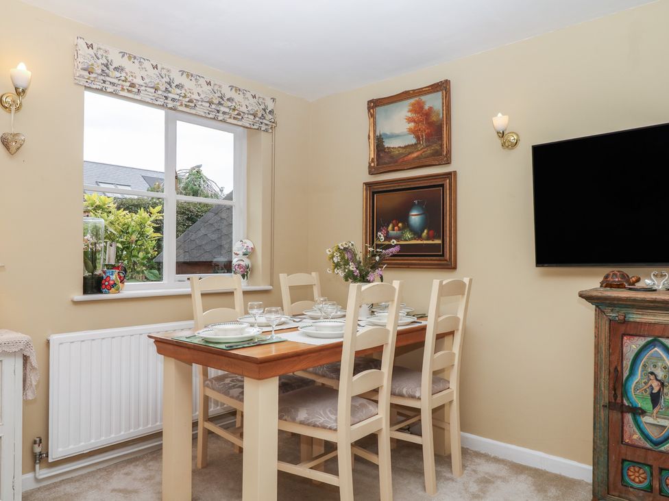 A dining room with a table set for meals at Mei Cottage in Pinhoe