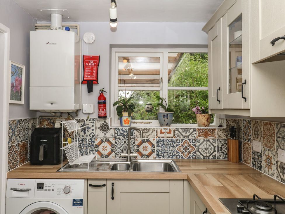 A kitchen with a sink and appliances at Mei Cottage in Pinhoe