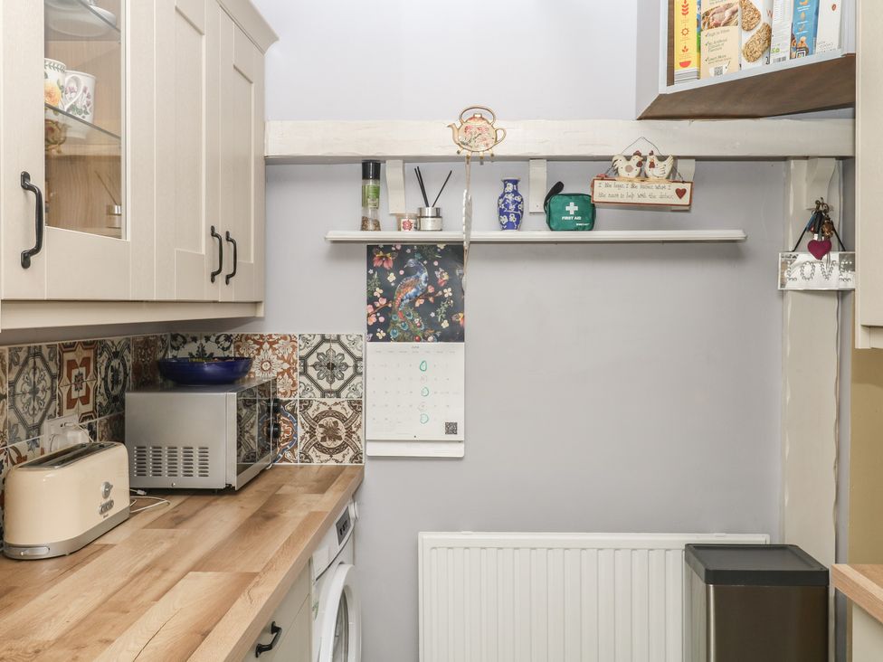 A kitchen with a shelf and a toaster at Mei Cottage in Pinhoe
