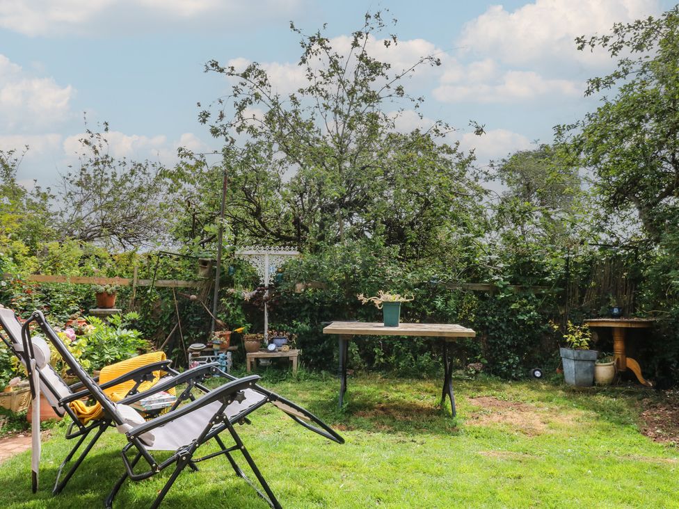 A garden with chairs and a table at Mei Cottage in Pinhoe