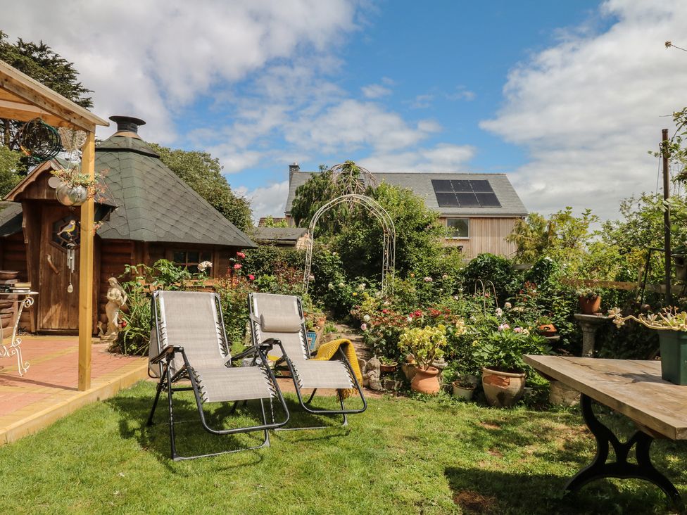 A garden with chairs and plants at Mei Cottage in Pinhoe