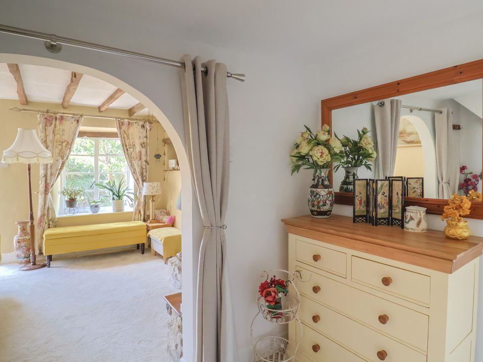 A living room with a dressing table and mirror at Mei's Cottage in Pinhoe
