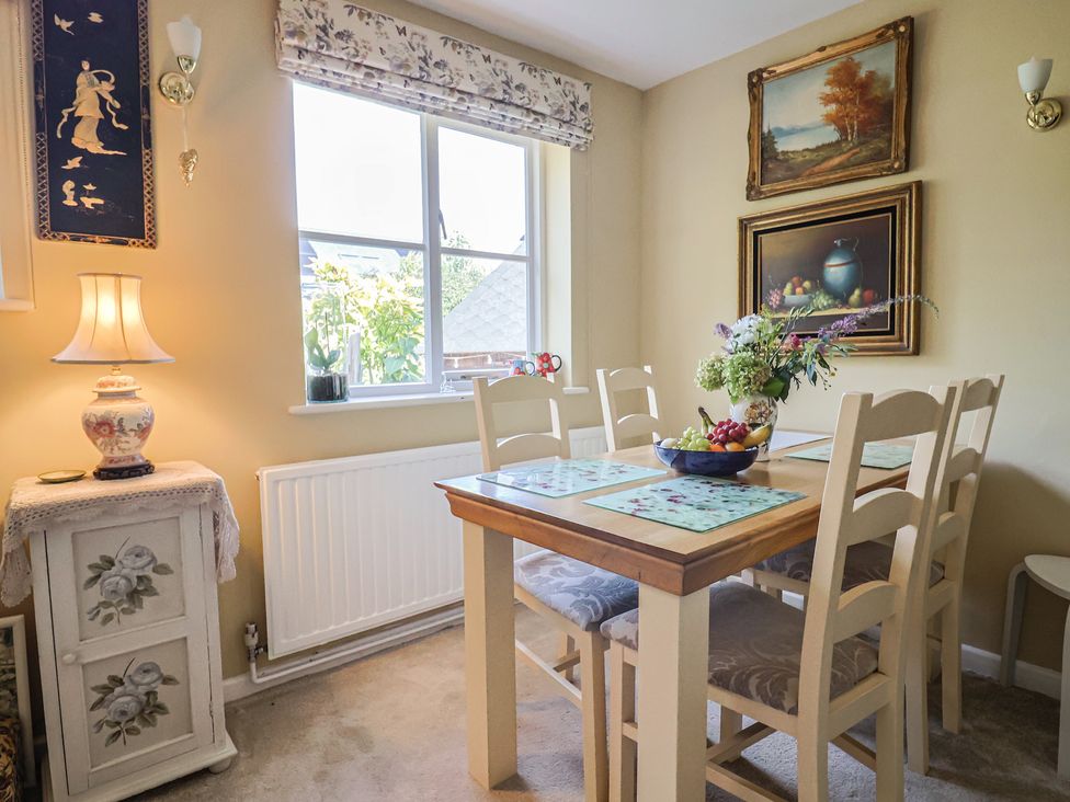 A dining room with a table and chairs at Mei's Cottage in Pinhoe