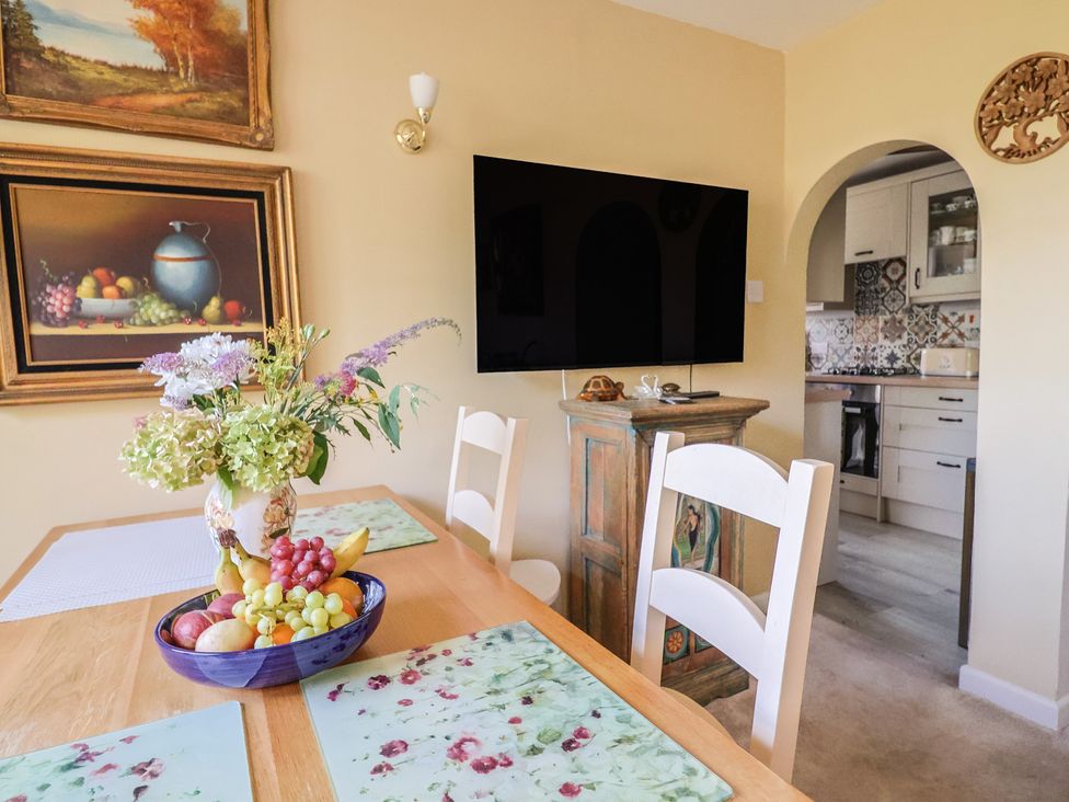A dining room with a table and chairs at Mei's Cottage in Pinhoe