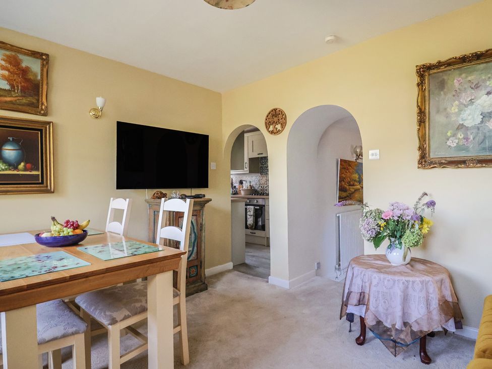 A dining room with a table and chairs at Mei's Cottage in Pinhoe