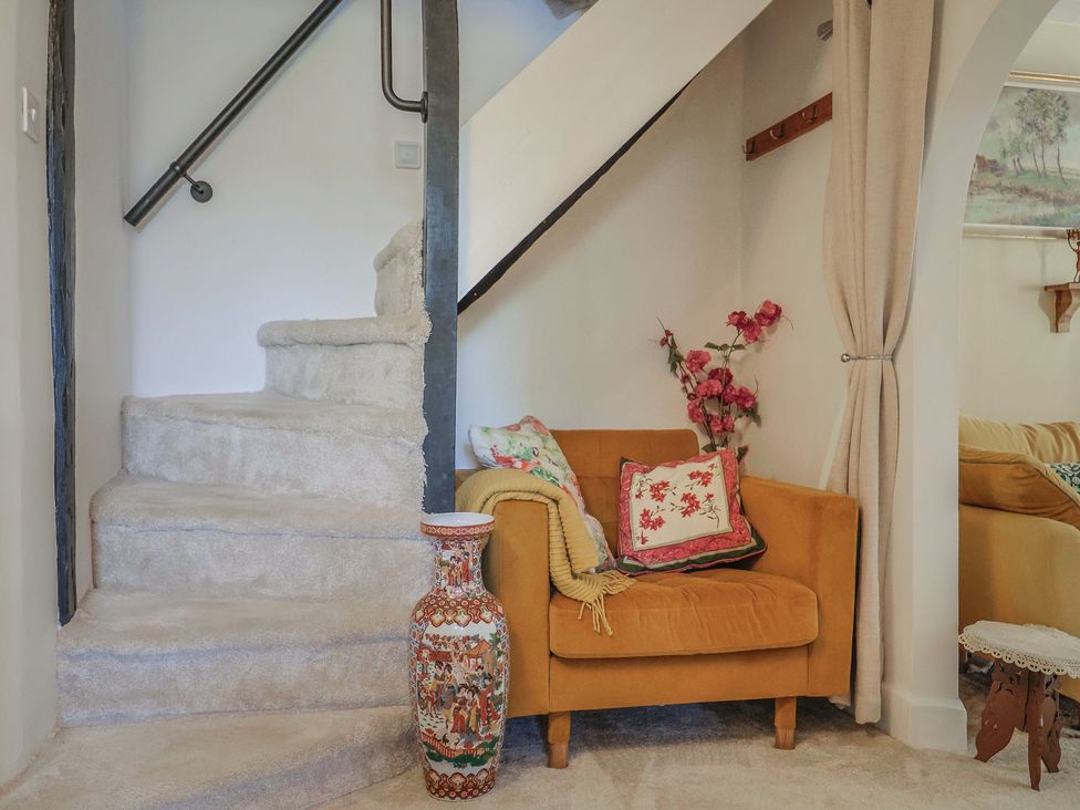 A living room with a staircase and couch at Mei's Cottage in Pinhoe